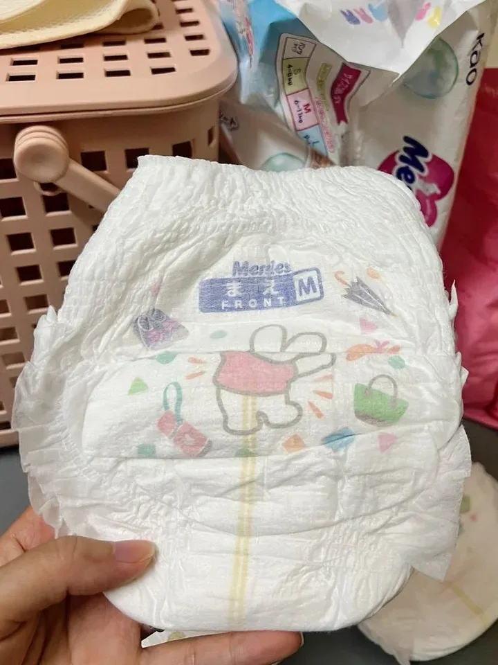 Mặt trước miếng bỉm quần Merries size M, in chữ まえ FRONT và hình thỏ mặc áo hồng