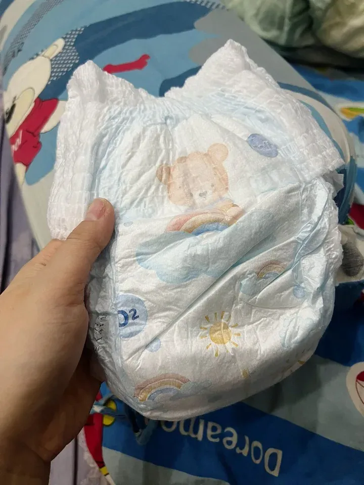 Mặt trước miếng tã quần Molfix Oxy size XXL màu trắng, in hình gấu, cầu vồng, mặt trời và chữ O2